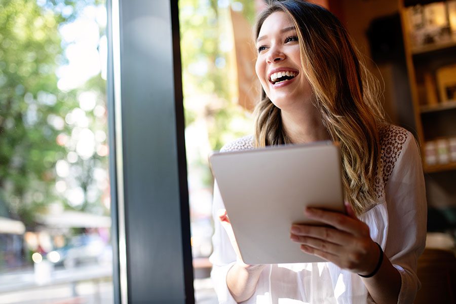 Video Library - Closeup Portrait of a Smiling Young Woman Using a Tablet While Standing in a Small Shop